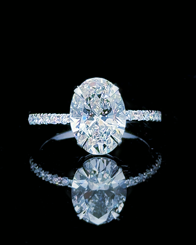 Main: White gold 5.50ct oval hidden halo ring with pave lab grown diamonds on black
Detail: Close-up of 5.50ct oval lab grown diamond with diamond-set white gold under-gallery
Side: White gold oval ring showing hidden halo, raised setting and lab grown diamond pave shoulders