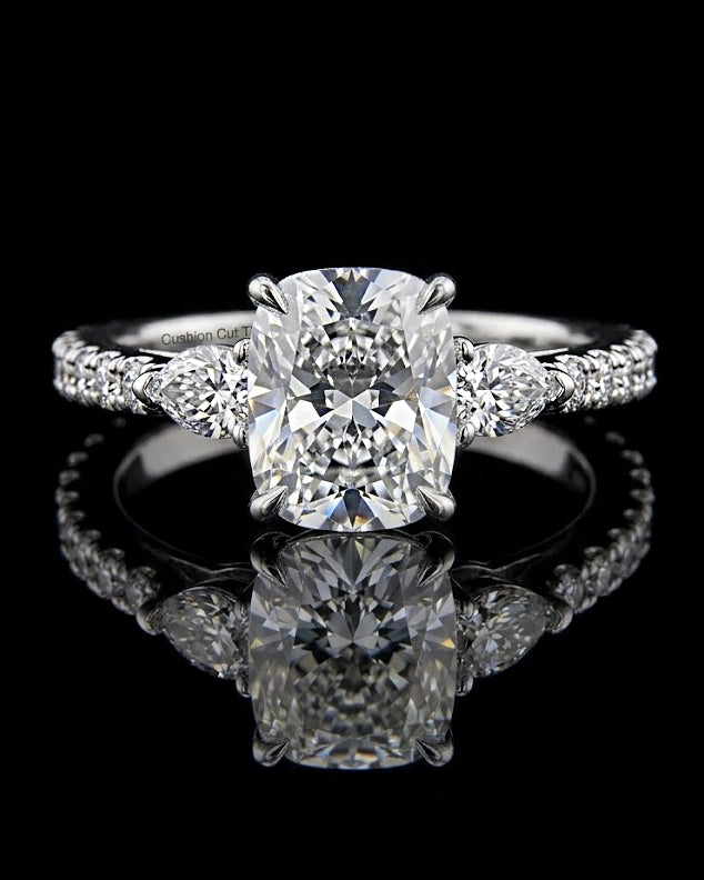 Main: White gold 2.65ct cushion three-stone ring with pear and pave lab grown diamonds on black
Detail: Close-up of 2.65ct cushion lab grown diamond with pear-cut sides in white gold
Side: White gold cushion ring with pear side stones and lab grown diamond pave shoulders