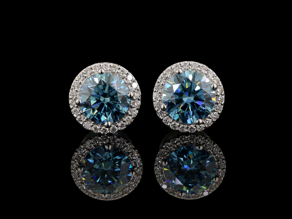 White gold halo earrings with blue round lab grown diamonds and white diamond halos on black