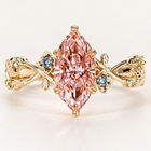 Fancy pink marquise cut lab grown diamond engagement ring with leaf-shaped gold prongs, floral vine shoulders and blue sapphire and peridot accents.