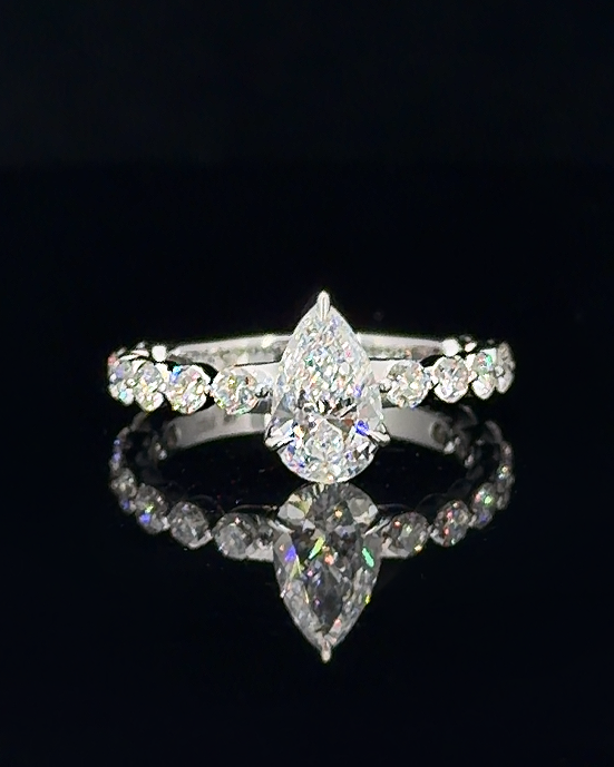 Main: White gold 1.01ct pear ring with round lab grown diamond shoulder stones on black
Detail: Close-up of 1.01ct pear lab grown diamond with round diamond accents in white gold
Side: White gold pear ring showing raised prong setting and round lab grown diamond shoulders