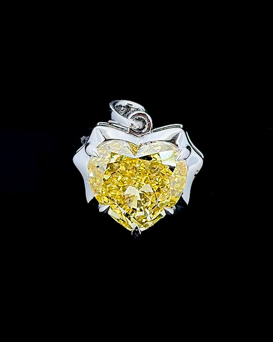 Main: White gold 6.14ct yellow heart pendant with diamond-set bail and lab grown diamonds on black
Detail: Close-up of 6.14ct yellow heart lab grown diamond in a sculptural white gold prong setting
Side: White gold heart pendant showing raised centre setting and five round lab grown diamonds along the bail