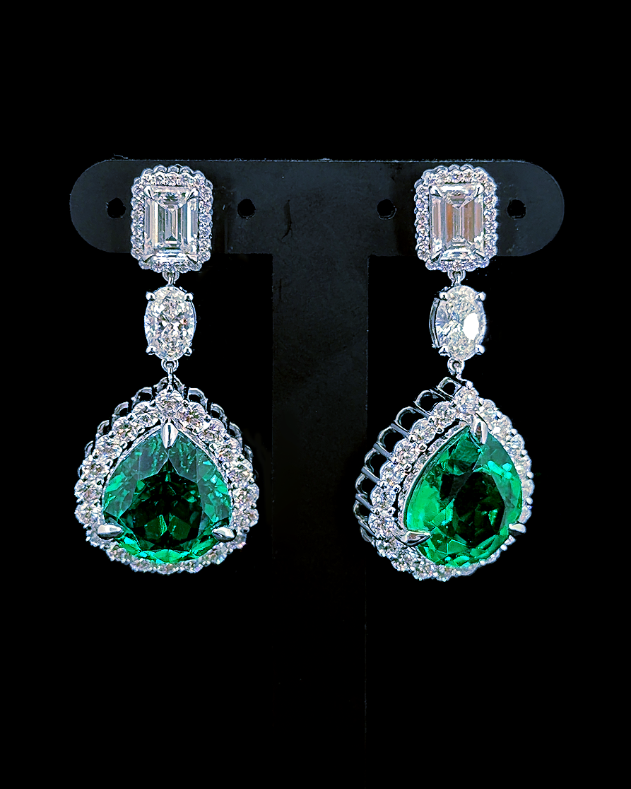 White gold green pear birthstone drop earrings with lab grown diamond halos on black