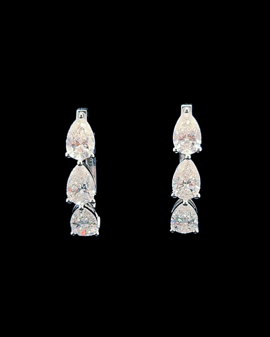 White gold graduated pear-shaped lab-grown diamond drop earrings on a black background