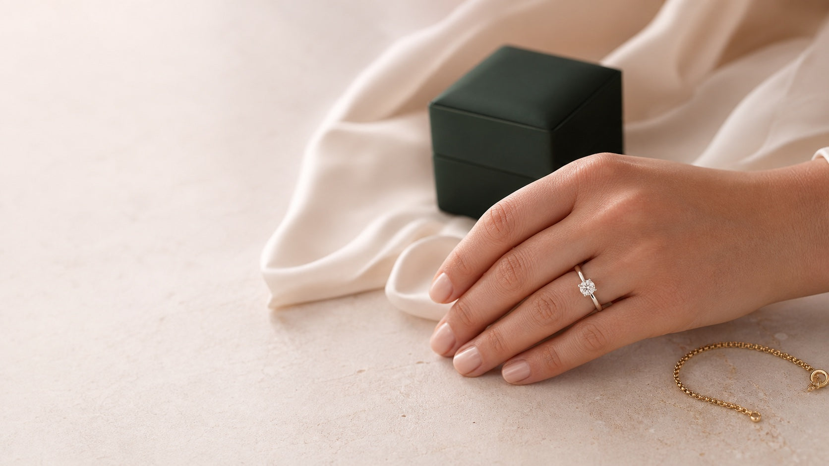 Woman wearing a lab-grown diamond ring beside a jewelry box