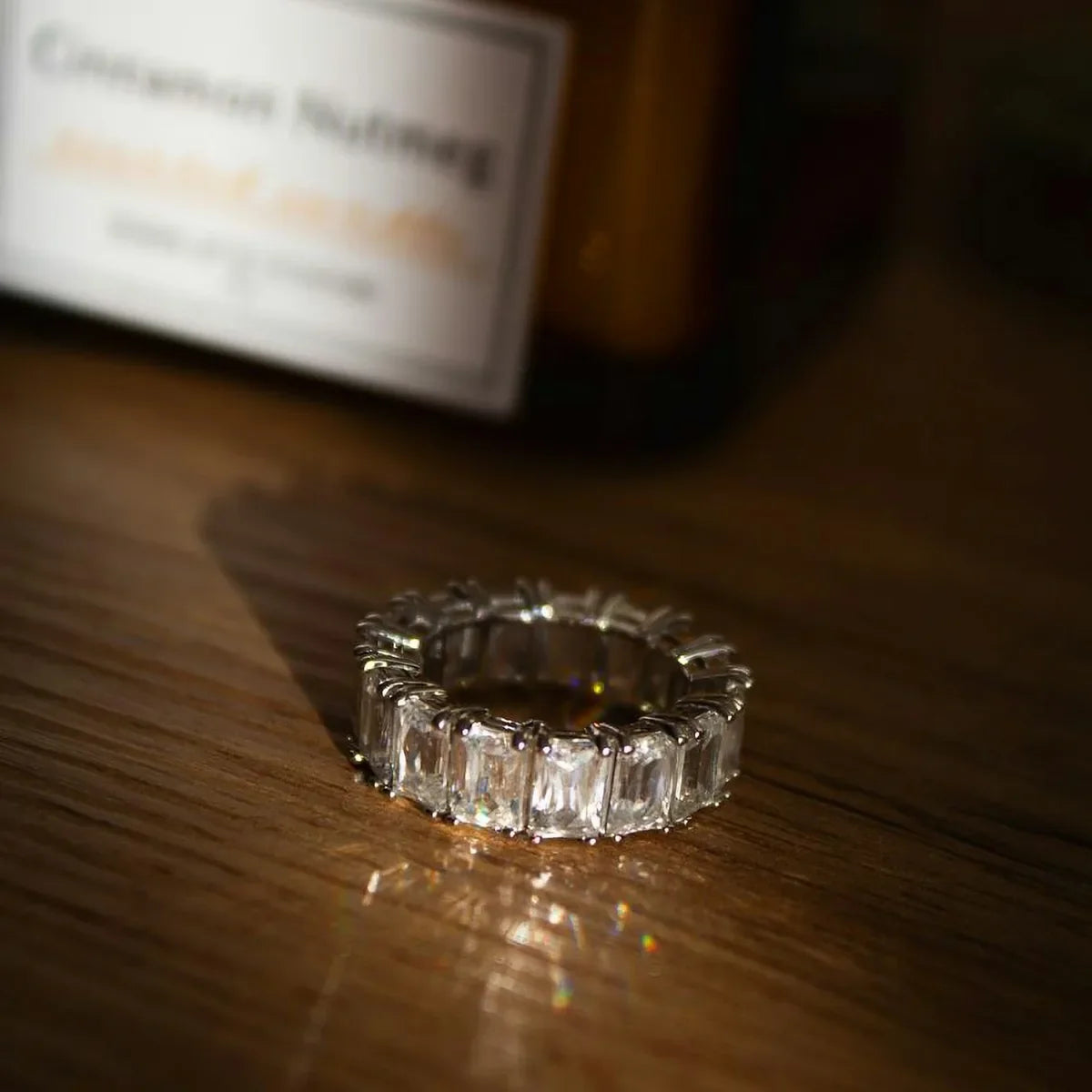 Emerald cut diamond ring on a wooden surface