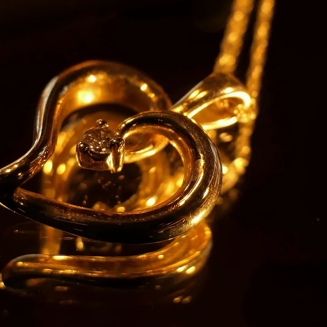 Gold necklace with a heart shaped diamond pendant