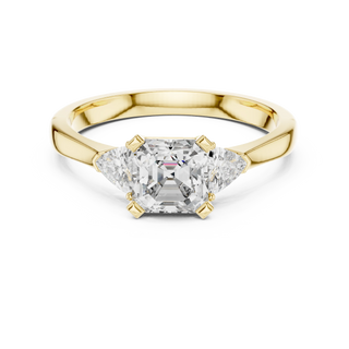 emerald diamond three stone engagement ring in yellow gold