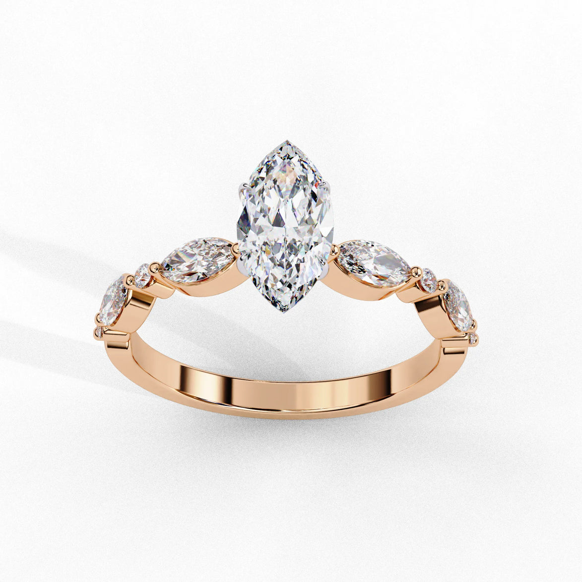 Side profile view of a rose gold marquise cut diamond ring highlighting the unique bezel-set accents along the band.