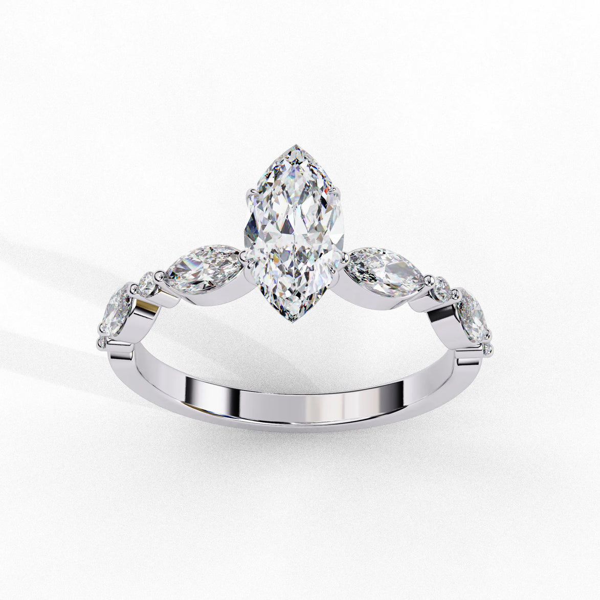 Side profile view of a white gold marquise cut diamond ring highlighting the unique bezel-set accents along the band.