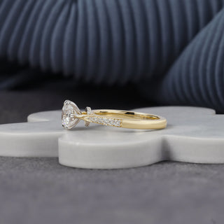 Round cut lab grown diamond engagement ring with 1.00 ct center, six-prong basket, pavé-set shoulders and hidden diamond accents in yellow gold with white-tone prongs.