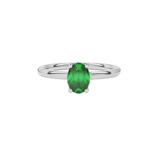 Close-up oval cut emerald green gemstone ring, white gold pavé basket.