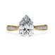 Gold ring with a pear-shaped diamond on a white background