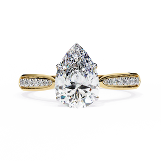 Gold ring with a pear-shaped diamond on a white background
