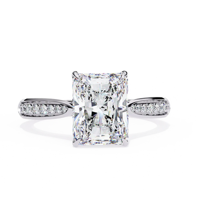 Diamond ring with a rectangular center stone on a white background