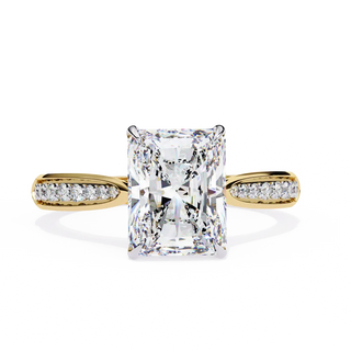 Gold ring with a large diamond and smaller diamonds on the band against a white background