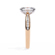 Rose gold ring with a large diamond and smaller diamonds on the band against a white background