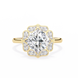 Gold ring with a large diamond and smaller diamonds on the band against a white background