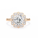 Rose gold ring with a large diamond and smaller diamonds on the band against a white background