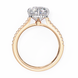 Rose gold ring with a large diamond and smaller diamonds on the band against a white background