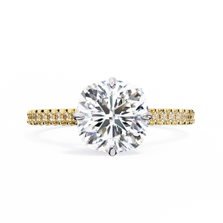 Gold ring with a large diamond and smaller diamonds on the band against a white background