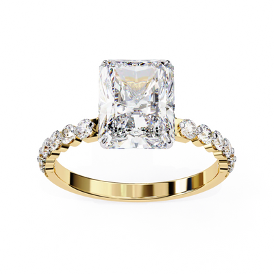 Gold ring with a large diamond and smaller diamonds on the band against a white background