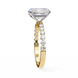 Gold ring with a large diamond and smaller diamonds on the band against a white background