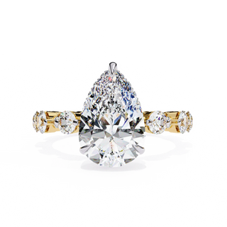 Pear Cut Lab Grown Diamond three-stone engagement ring in yellow gold with round diamond shoulders.