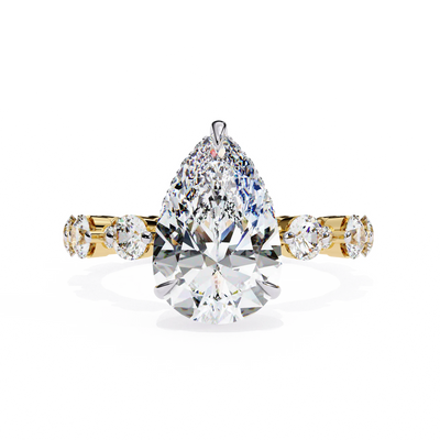 Pear Cut Lab Grown Diamond three-stone engagement ring in yellow gold with round diamond shoulders.