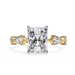 Front-facing view of a yellow gold radiant diamond ring with pear side stones.