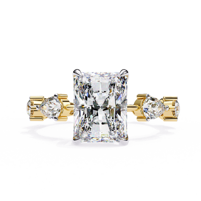 Front-facing view of a yellow gold radiant diamond ring with pear side stones.