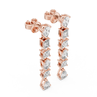 Side profile of rose gold cascading pear, princess, oval, and emerald cut diamond drop earrings.