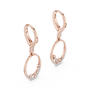 Side profile of rose gold oval drop hoop earrings with round and baguette diamonds.