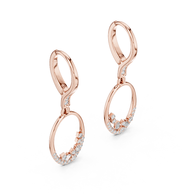 Side profile of rose gold oval drop hoop earrings with round and baguette diamonds.