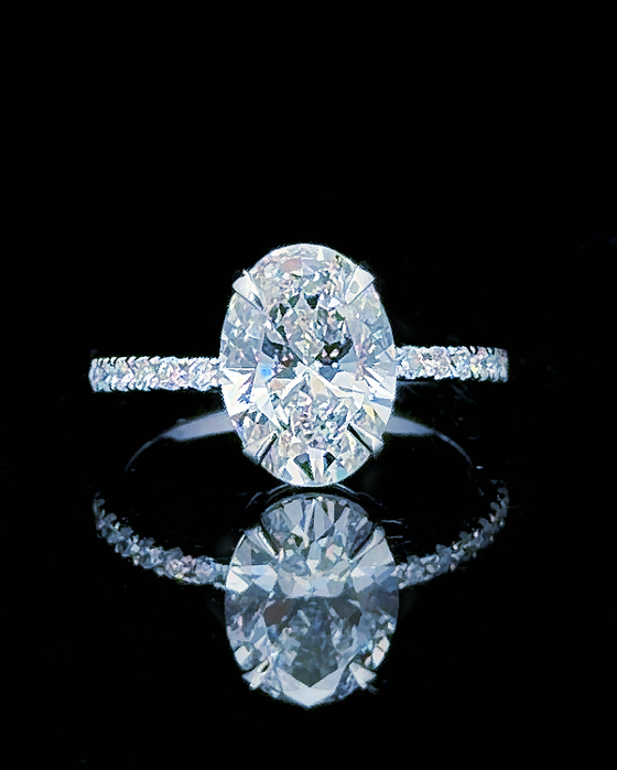 Main: White gold 5.50ct oval hidden halo ring with pave lab grown diamonds on black
Detail: Close-up of 5.50ct oval lab grown diamond with diamond-set white gold under-gallery
Side: White gold oval ring showing hidden halo, raised setting and lab grown diamond pave shoulders