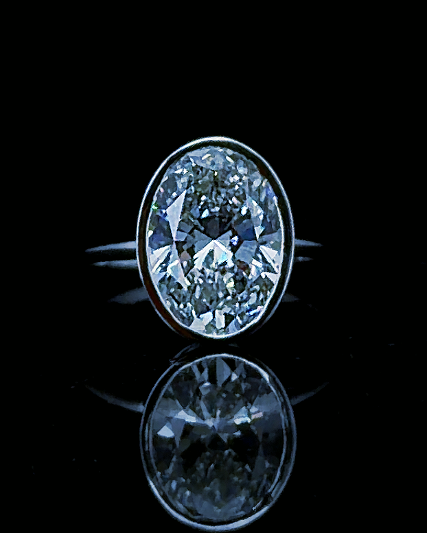 Main: White gold 3.56ct oval bezel solitaire ring with lab grown diamond centre on black
Detail: Close-up of 3.56ct oval lab grown diamond enclosed in a polished white gold bezel
Side: White gold oval solitaire ring showing raised bezel profile and tapered shoulders