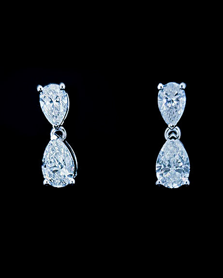 White gold pear drop earrings with four lab grown diamonds on black