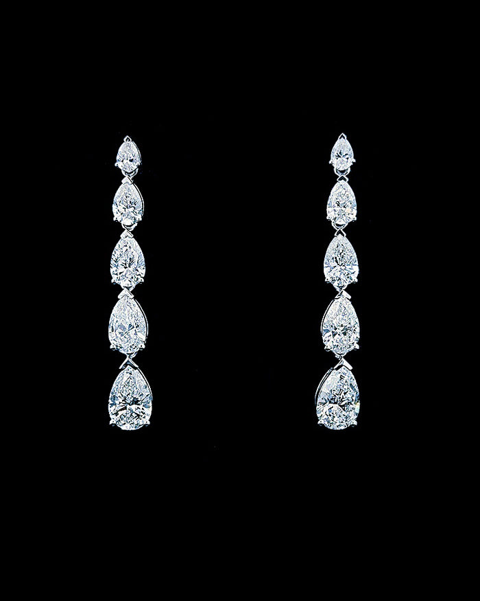 Main: White gold graduated pear drop earrings with 5.29ct lab grown diamonds on black
Detail: Close-up of five graduated pear lab grown diamonds forming each white gold drop earring
Side: White gold pear diamond drop earrings showing articulated settings and post-and-butterfly fastening