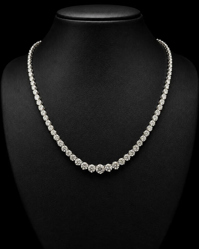 A sparkling diamond tennis necklace displayed on a black jewelry bust against a black background.
