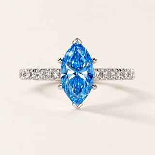 Fancy blue marquise cut lab grown diamond engagement ring with protective six-prong center setting and round diamond pavé shoulders in polished white gold.