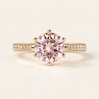 Fancy pink round cut lab grown diamond engagement ring with eight-prong yellow gold basket, white diamond pavé shoulders and polished gold shank.