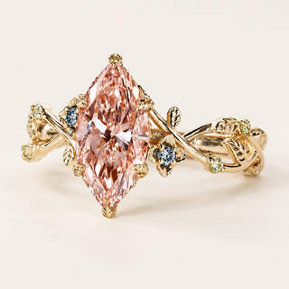 Fancy pink marquise cut lab grown diamond engagement ring with leaf-shaped gold prongs, floral vine shoulders and blue sapphire and peridot accents.