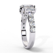 Side profile view of a white gold radiant cut three-stone diamond ring showing the diamond-accented band.