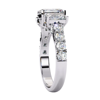 Side profile view of a white gold radiant cut three-stone diamond ring showing the diamond-accented band.