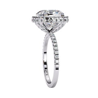 Close-up angled shot of a white gold cushion cut diamond double halo engagement ring highlighting the pavé shoulders.