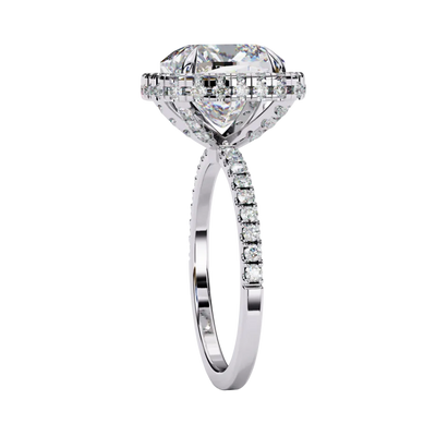 Close-up angled shot of a white gold cushion cut diamond double halo engagement ring highlighting the pavé shoulders.