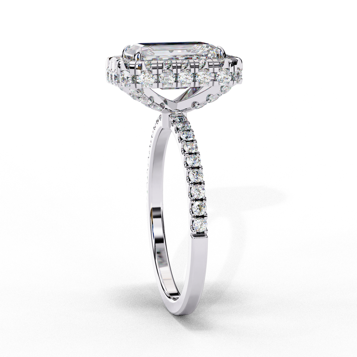 Side profile view of a white gold emerald cut diamond ring showing the diamond-accented pavé band.