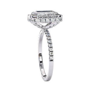Side profile view of a white gold emerald cut diamond ring showing the diamond-accented pavé band.