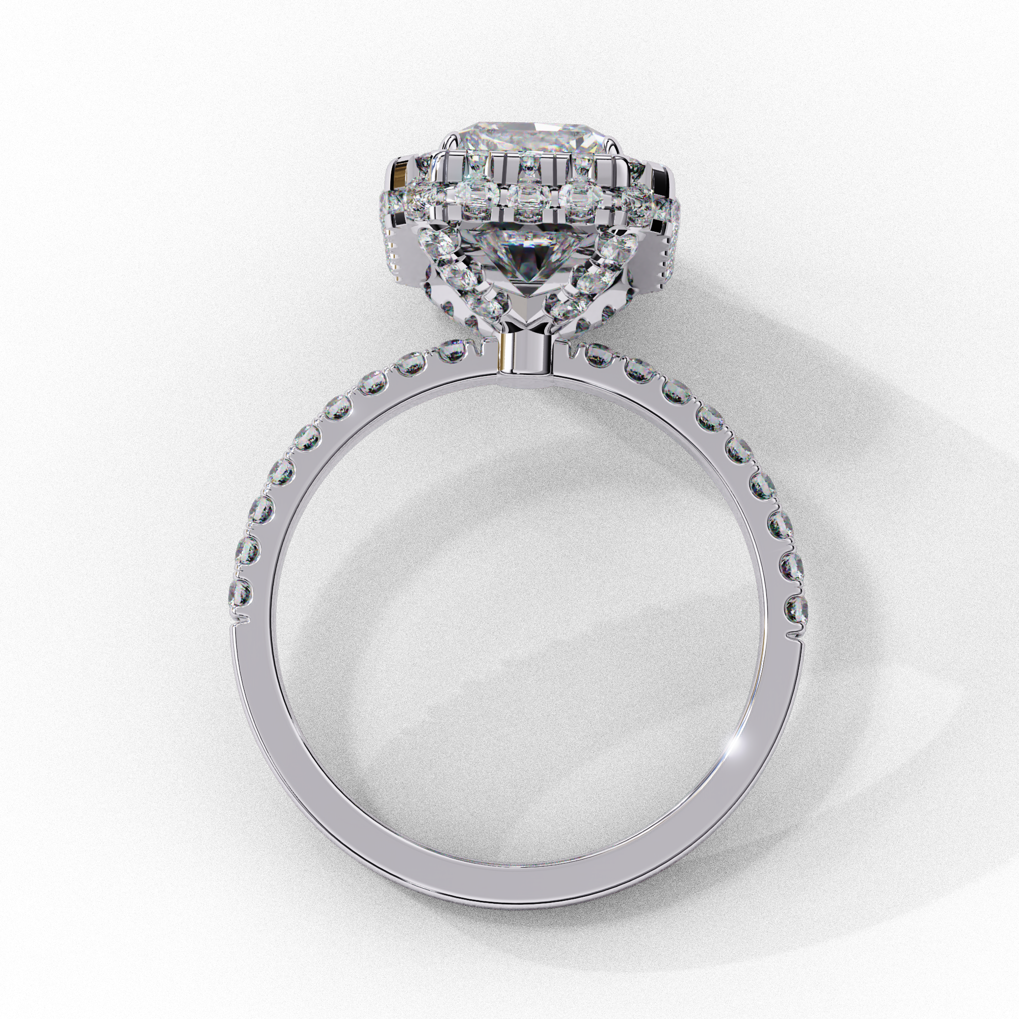 Side profile view of a white gold emerald cut diamond double halo engagement ring showing the elevated cathedral gallery.
