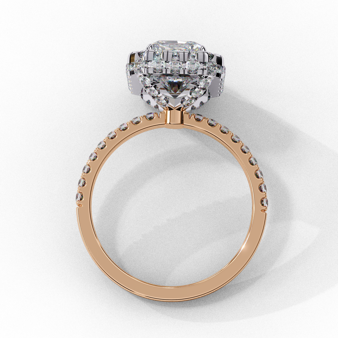 Side profile view of a rose gold emerald cut diamond double halo engagement ring showing the elevated cathedral gallery.